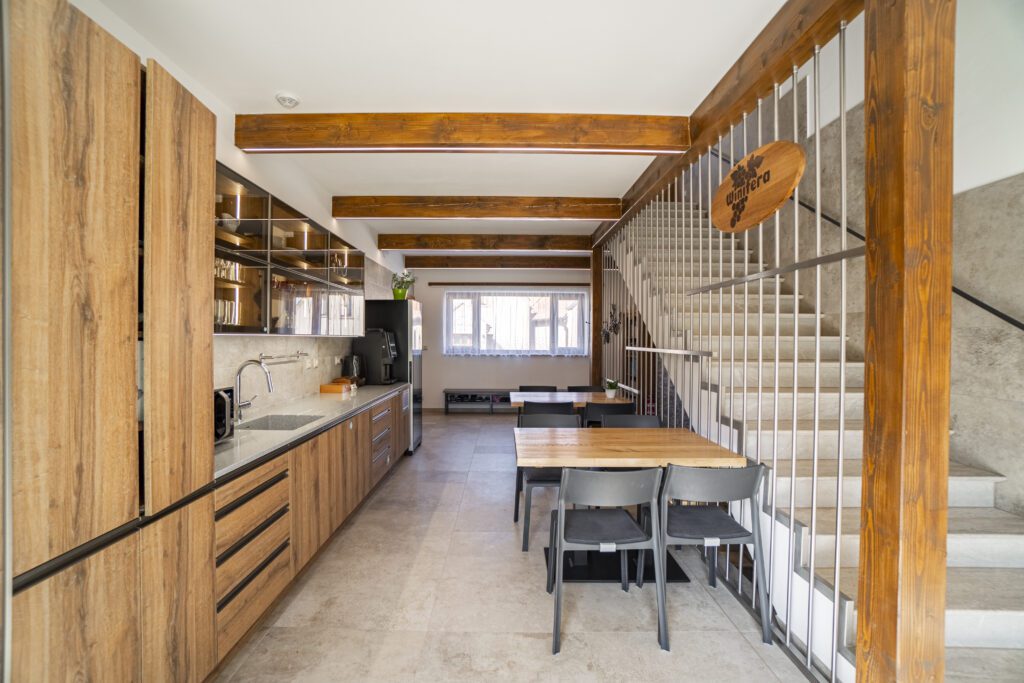 Společnou halou se prochází po schodech nahoru do apartmánů Penzionu Winifera.