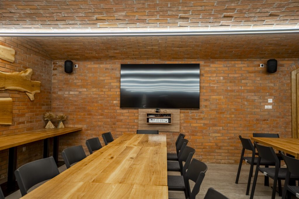 Ve velkém sklepě, který se dá pronajmout, může firma využít velkou televizi s úhlopříčkou 85 palců k zobrazení firemních prezentací.